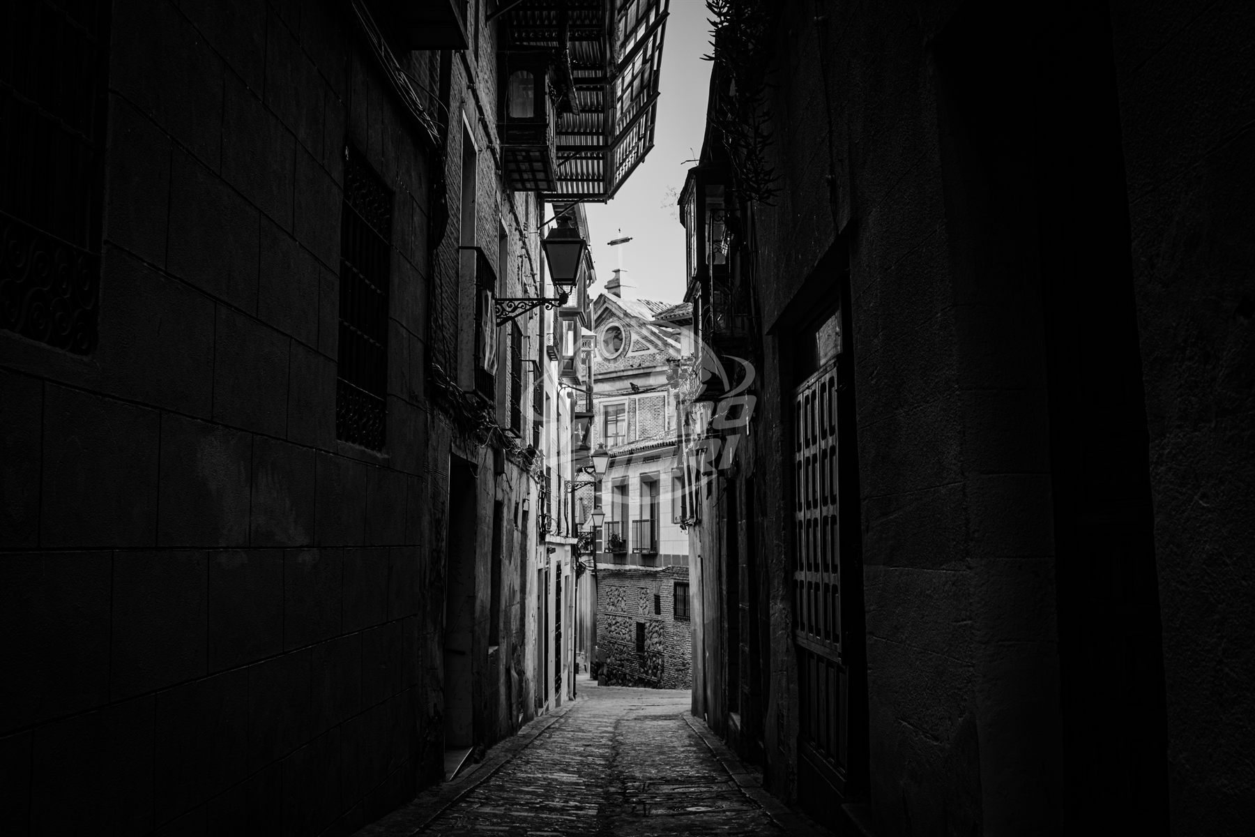 Callejón estrecho entre edificios antiguos, blanco y negro