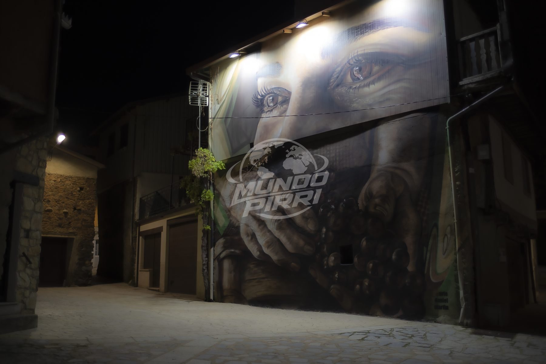 Mural callejero iluminado de noche