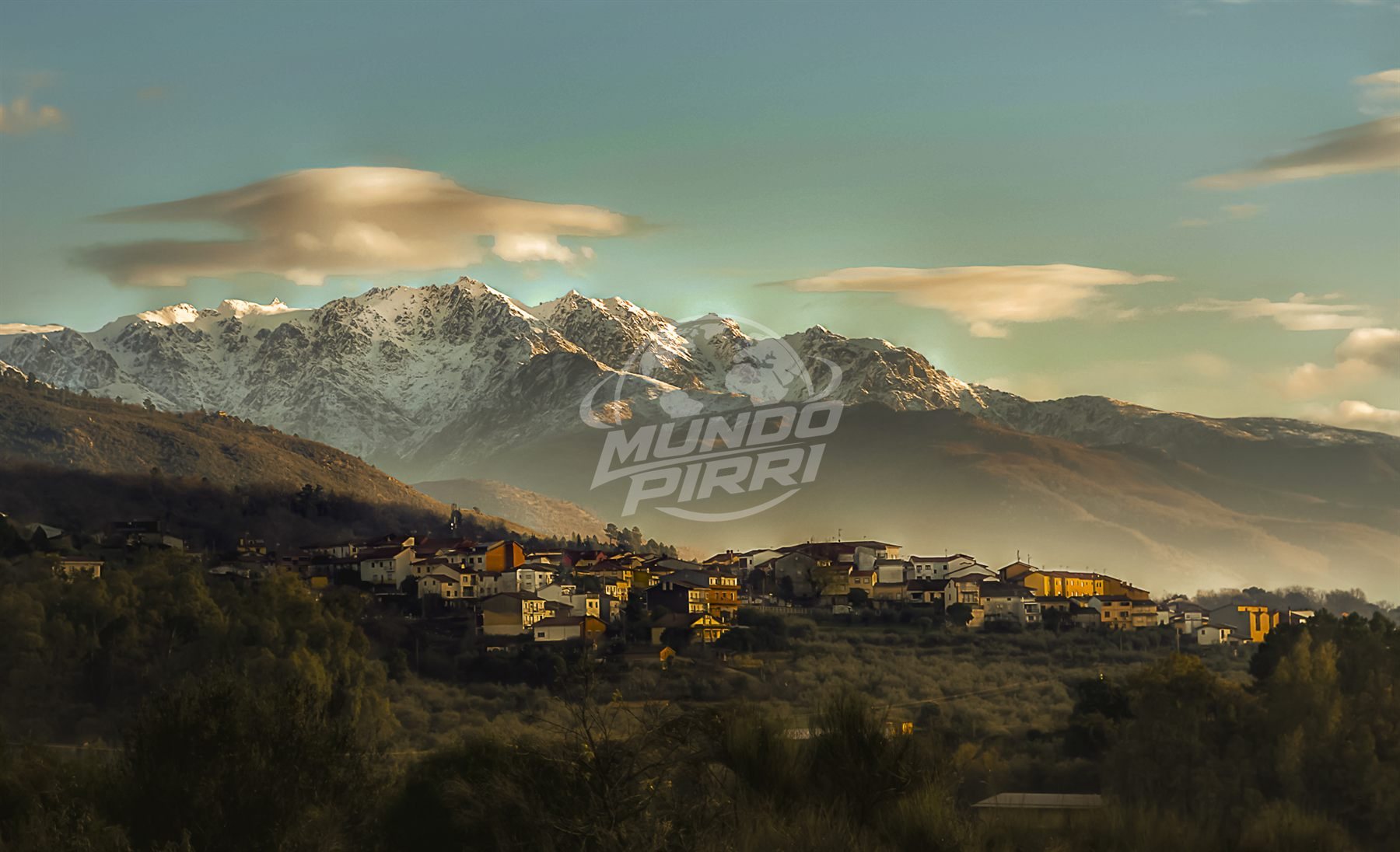 Pueblo de montaña con cordillera nevada al fondo